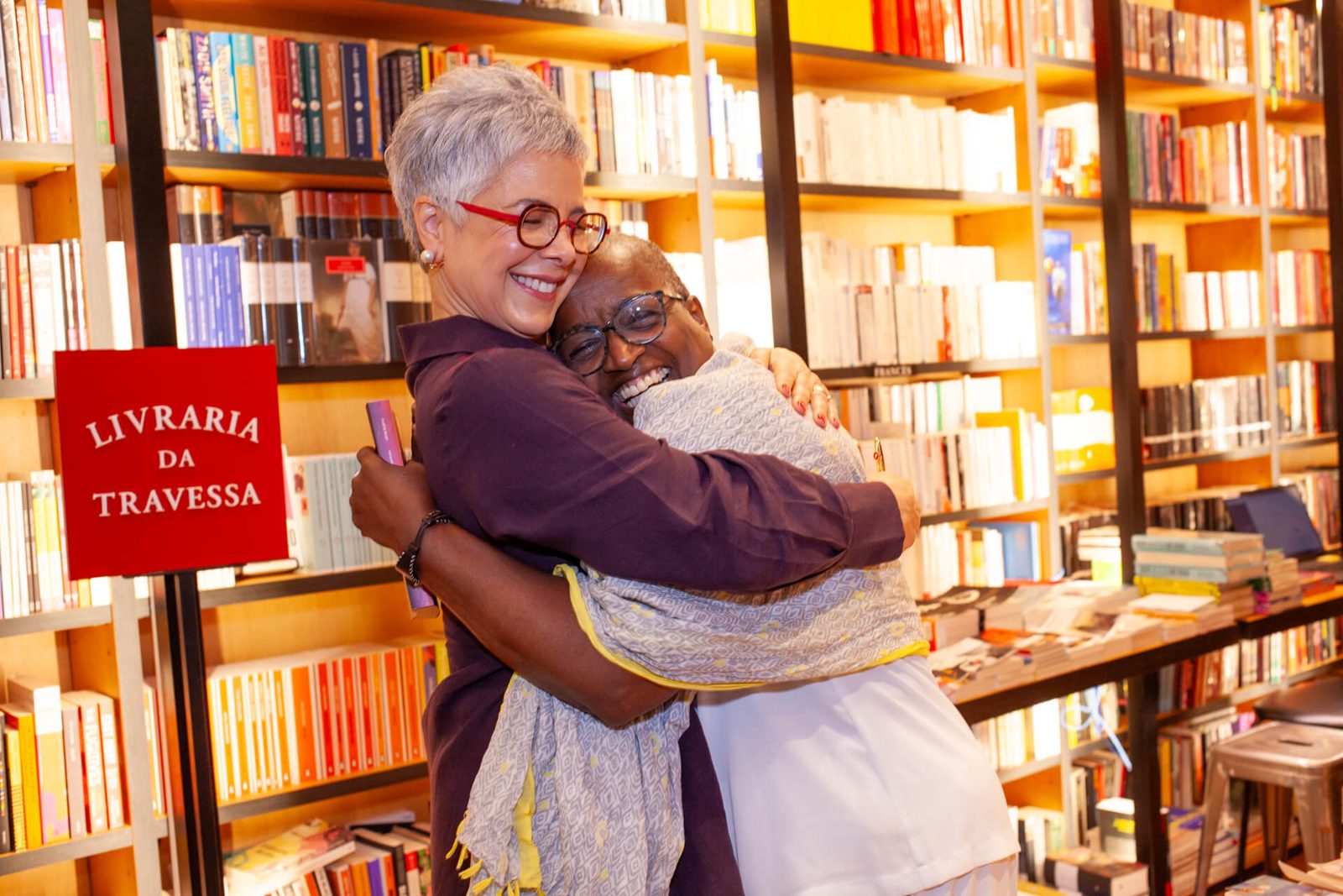Vania Bueno abraçando uma convidada no lançamento do livro