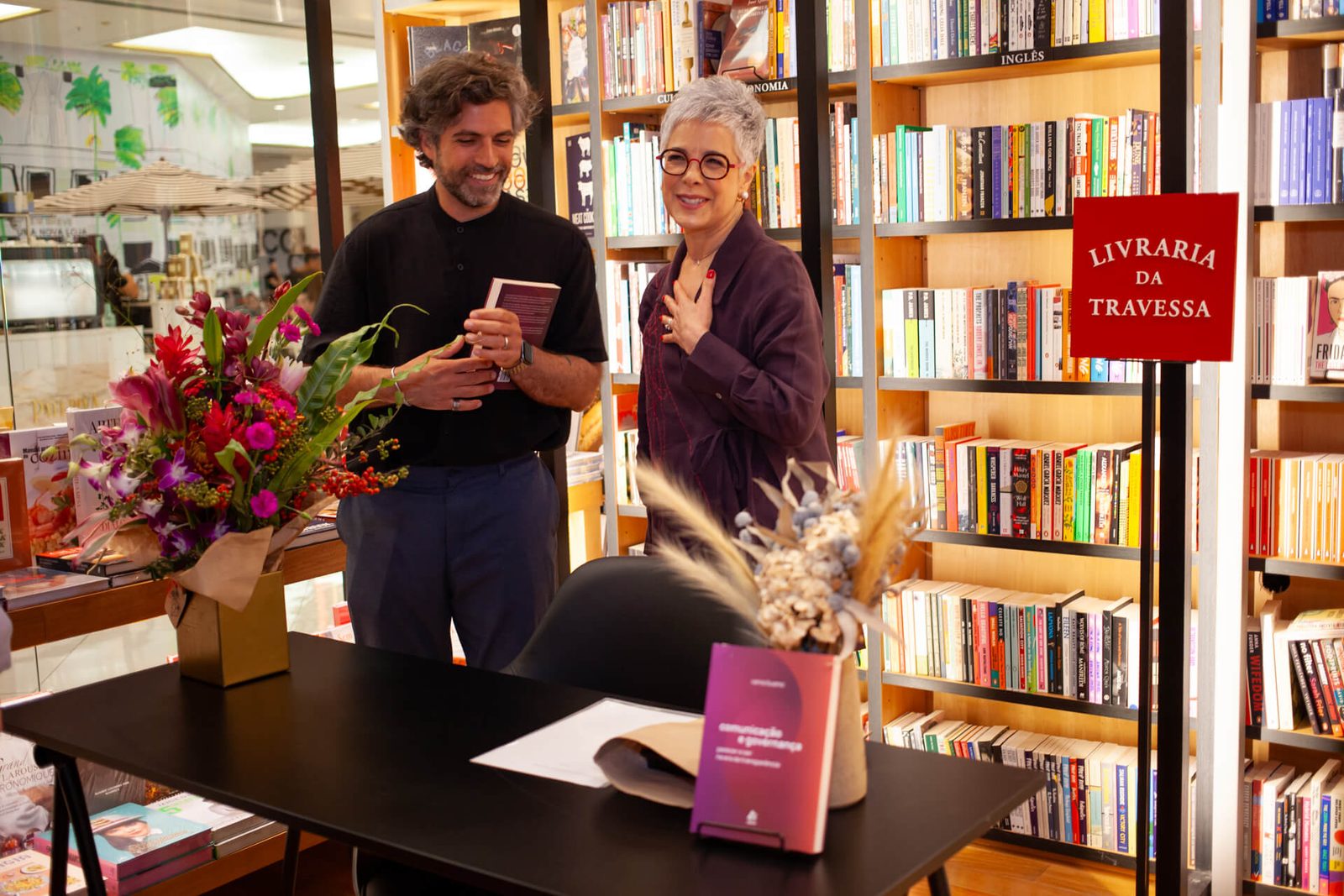 Vania Bueno recebendo flores na mesa de autógrafos