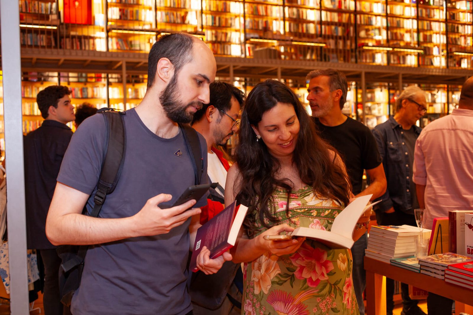Leitores folheando o livro durante o lançamento
